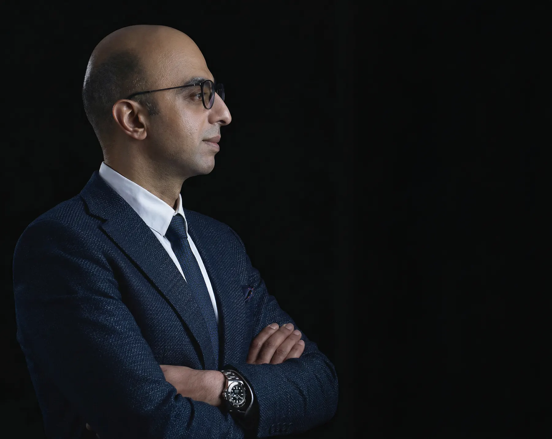 Dr. Ahmed in profile, arms folded