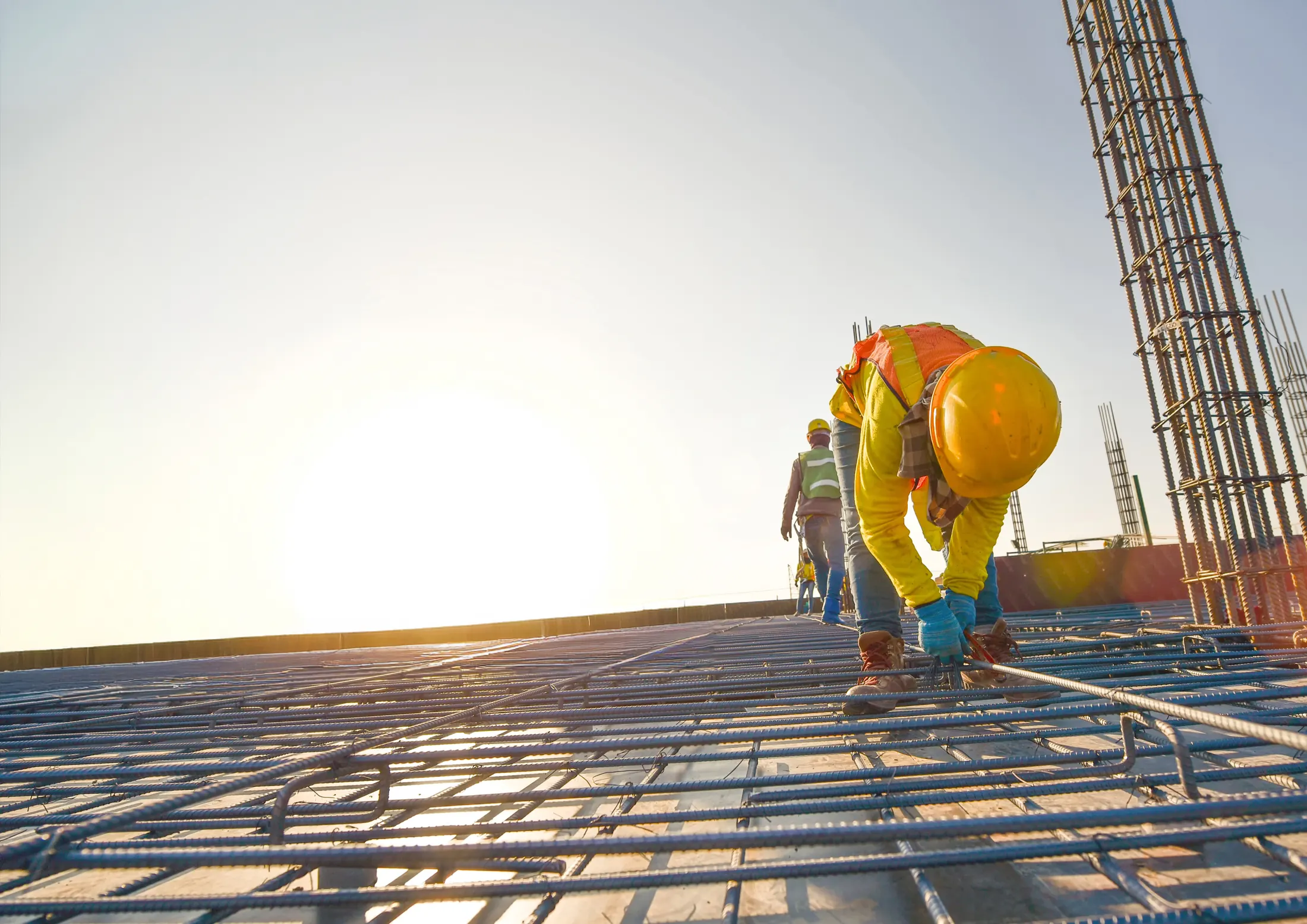 Engineer tying rebar on a slab at sunrise