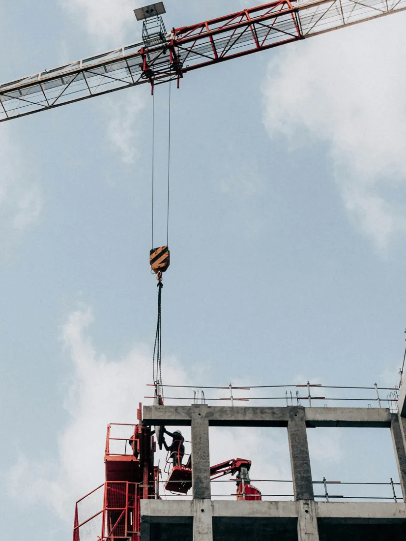 Tower crane lifting steel above a building frame